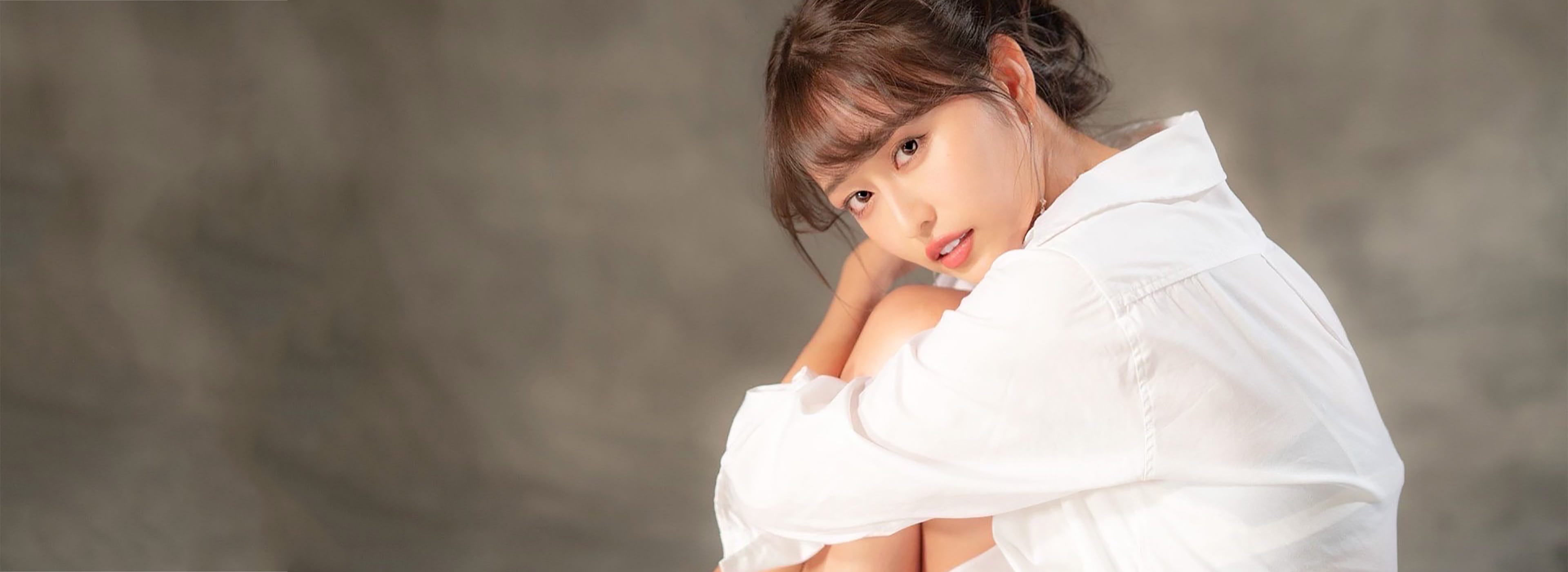 こちらを見つめている白いシャツを来た女性